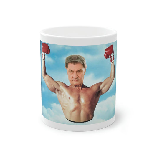 Markus Söder Meme Tasse zeigt Söder in Siegerpose mit Boxhandschuhen und einem ernsten Gesicht